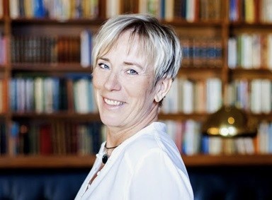 A smiling woman with short blond hair.